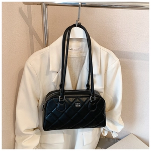 Detail of black quilted bowling bag with rhombus stitching and metallic logo lettering