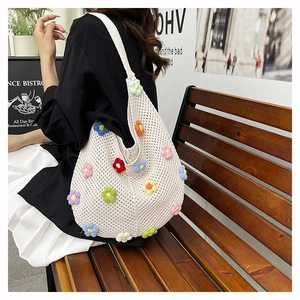 Détail du sac cabas en tricot blanc avec des motifs de fleurs colorées crochetées à la main