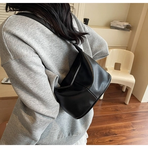 Détail du sac à bandoulière en cuir mat noir avec fermeture éclair en métal argenté
