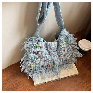 Détail du sac au crochet bleu clair avec perles colorées et longues franges