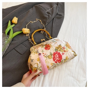 Detail view of floral satin handbag featuring bamboo handle and pink silk tassel