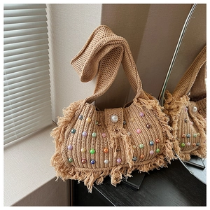 Détail du sac en tricot beige fait main avec des perles colorées et de longues franges