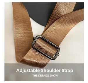 Detailed macro view of the brown adjustable nylon shoulder strap and matte metal buckle