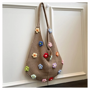 Gros plan du sac cabas marron tissé main avec des motifs détaillés de fleurs crochetées en 3D