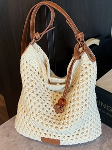 Handcrafted hollow crochet tote bag in beige with dark brown leather straps for summer