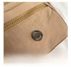 Close-up of khaki nylon fabric texture and metallic JIN YU BO logo detailing