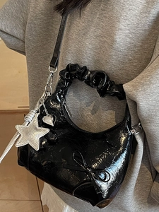 Black bow shoulder bag with star charms and ruched handle in faux leather finish
