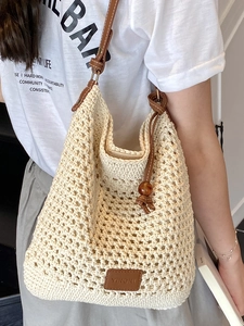 Chic cream hollow woven tote bag with brown leather straps and amber bead for beach vacation