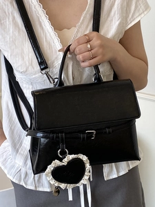 Sac à dos polyvalent en cuir noir avec breloque coeur en dentelle et détails argentés