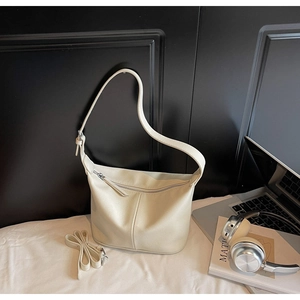 Détail du sac hobo en cuir crème avec texture fine et bandoulière amovible incluse