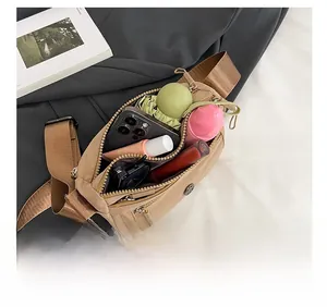 Detail showing high-capacity interior of khaki nylon crossbody bag with daily essentials