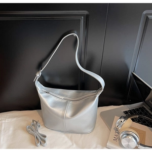 Vue détaillée du sac Hobo argenté métallisé avec bandoulière réglable sur tissu blanc
