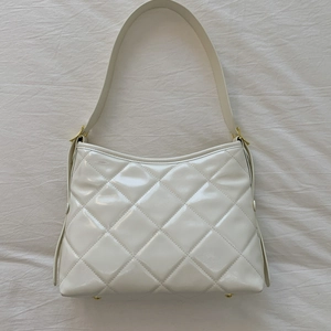 Vue de dessus d'un sac sous les bras en cuir matelassé blanc brillant avec boucle dorée