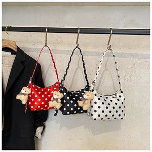 Three spotted underarm bags in red, black, and white with plush bear charms