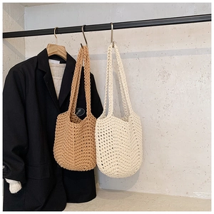 Detail of hand-crocheted knit tote bags in brown and cream with a textured weave