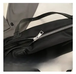 Close-up detail of smooth silver metal zipper on durable black nylon tote bag