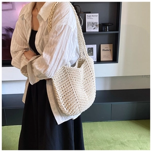 Detail of off-white woven tote bag texture and wide strap on minimalist background