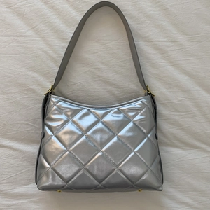 Vue détaillée de la texture matelassée argentée et de la finition métallique du sac