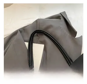 Detail of comfortable black leather tote handle with lychee texture and fine stitching
