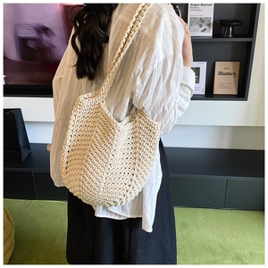 Close-up of cream white chunky knit crochet tote bag with wide shoulder strap on model