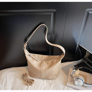 Détail du sac à main beige en forme de demi-lune avec deux bandoulières interchangeables