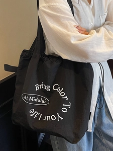 Minimalist black drawstring tote bag with white lettering print for casual daily wear