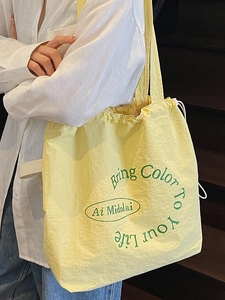 Minimalist canvas drawstring tote bag in pale yellow with green graphic print for women
