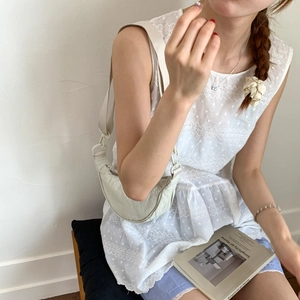 Close-up of lightweight crescent bag in ivory nylon with adjustable strap and casual styling
