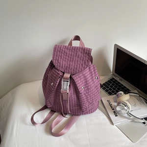 Detail view of large capacity purple plaid backpack with drawstring closure and pockets