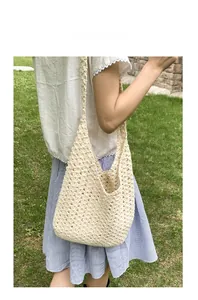 Gros plan détaillé de la texture du sac cabas au crochet crème sur de l'herbe verte