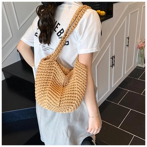 Detail of hand-woven straw shoulder bag showing the textured finish and large capacity