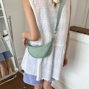 Detail view of mint green nylon crescent bag with adjustable wide shoulder strap