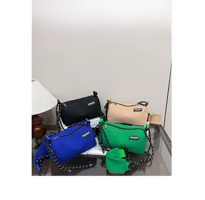Detail of colorful canvas cylinder crossbody bags with striped rope straps in four colors