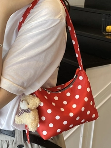 Red shoulder bag with white polka dots featuring a cute plush bear pendant accessory
