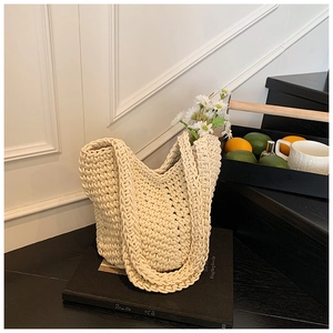 Detailed macro of a cream crochet tote bag with thick woven honeycomb texture and handles