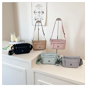 Detail view of five versatile nylon crossbody bags in various colors on a soft background