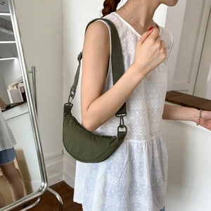 Detail view of olive green crescent bag with wide shoulder strap and matte nylon finish