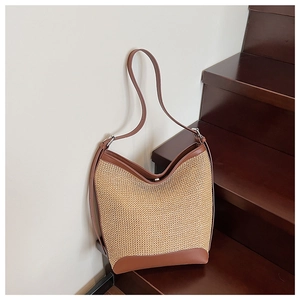 Détail du sac cabas en paille tissée avec bordure en cuir marron et fine bandoulière