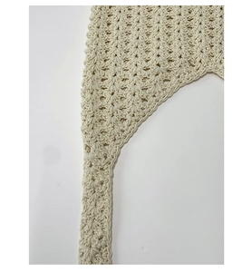 Détail de la texture en maille crochetée à la main crème avec motif ajouré sur le sac