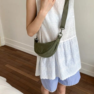 Olive green crescent crossbody bag with wide shoulder strap shown on a female model