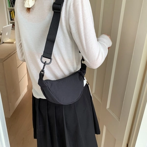 Close-up of black nylon crescent bag with adjustable wide strap shown on model