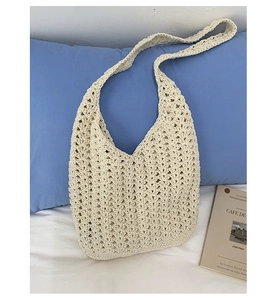 Détail du sac cabas en coton tressé crème avec motif floral au crochet sur literie blanche