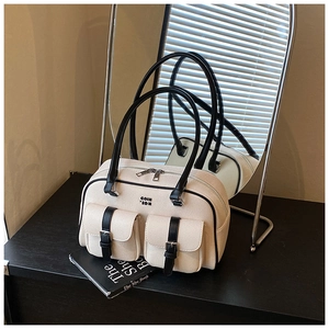 Detail view of canvas Boston bag featuring black leather trim and metal buckle pockets