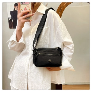 Practical black nylon crossbody bag shown in a mirror selfie for real size reference