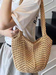 Minimalist handmade woven straw tote bag in light khaki, perfect for summer beach holidays