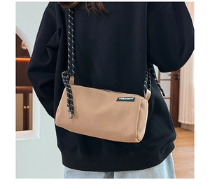 Detail view of the cylindrical canvas crossbody bag with a thick woven rope shoulder strap