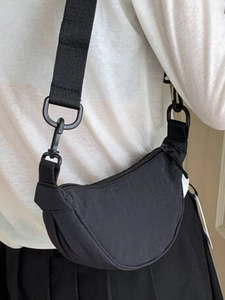 Minimalist black nylon crescent crossbody bag with adjustable wide fabric shoulder strap