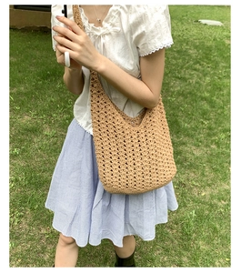 Détail du motif en tricot évidé fait main sur ce sac fourre-tout beige pour les vacances