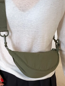 Olive green crescent shoulder bag in nylon worn as a crossbody bag for women