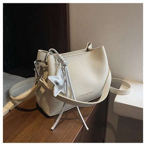 Détail du sac seau en cuir grainé avec pendentif étoile argenté et gravure mode